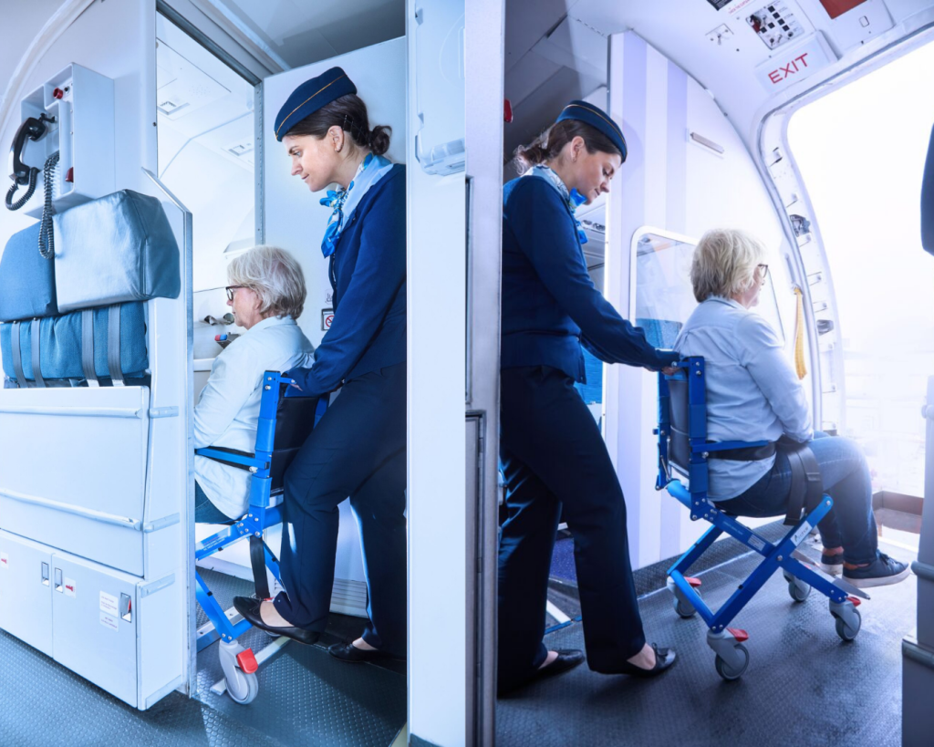 Flight attendant assisting a passenger using an Airchair II onboard wheelchair to access the aircraft lavatory.