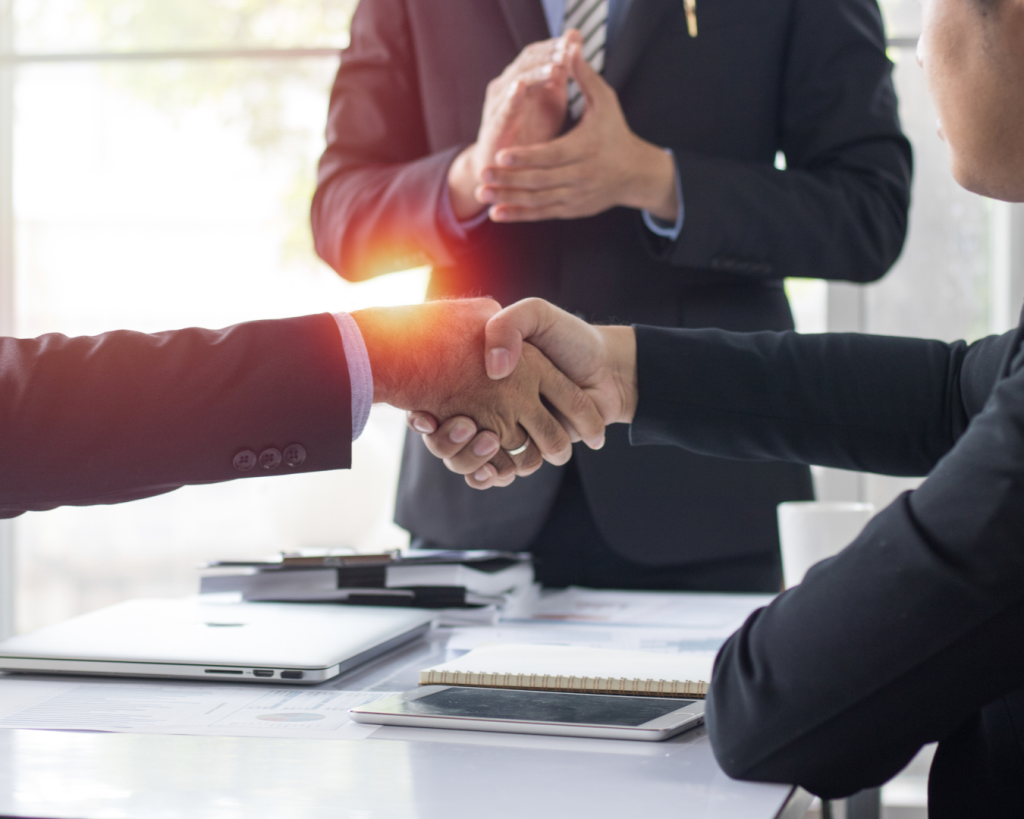 Business professionals shaking hands during a partnership meeting, symbolizing collaboration and business reliability