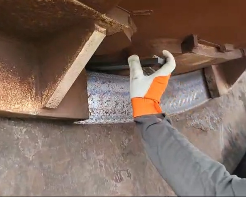 Operator applying Anion Slick-Bar lubricant to the contact area between the kiln tyre and kiln shell during Rotary Kiln maintenance.