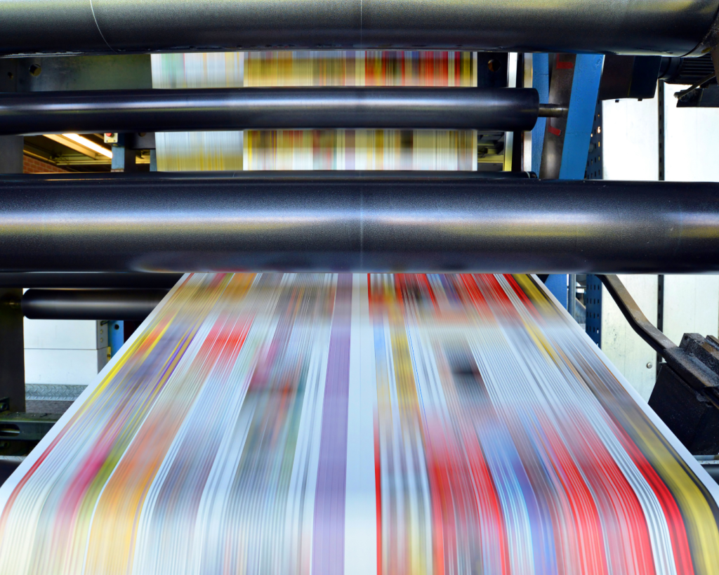 Commercial offset printing machine running high-speed full-color print production.